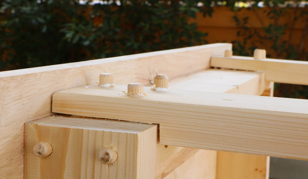 Close-up of hardwood dowel joints with wood glue in premium furniture frame construction