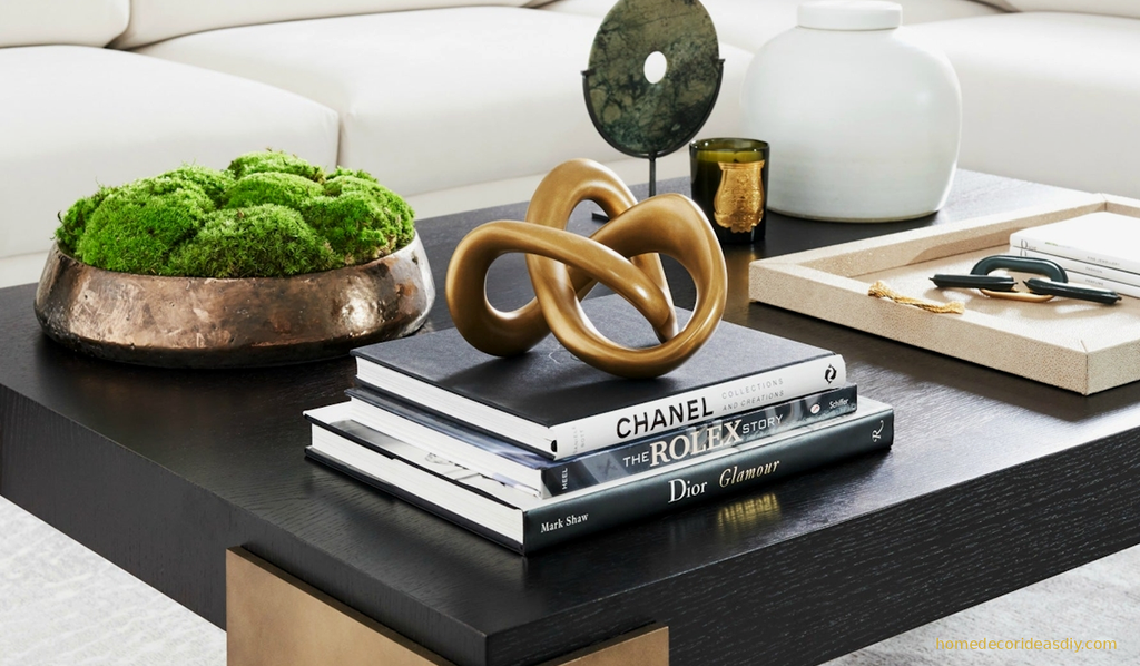 Low profile luxury decorative objects styled on a modern coffee table with stacked books and a sculptural brass piece  proving thoughtful home decor earns its keep without blocking conversation.