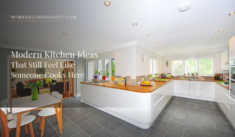 Lived-in modern kitchen with white flat-front units, a wood worktop, fruit on the island and a dining table in the foreground