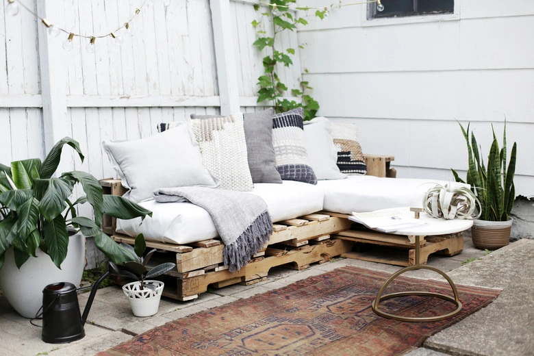 Stacked pallet patio sofa with outdoor cushions budget DIY pallet furniture idea