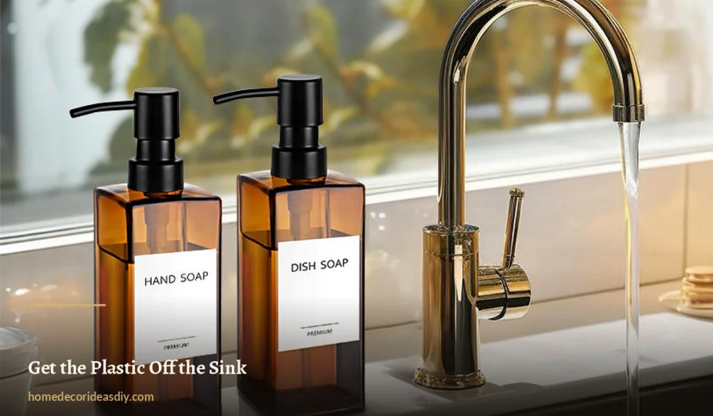 Two amber glass soap dispensers labelled hand soap and dish soap beside a gold kitchen tap