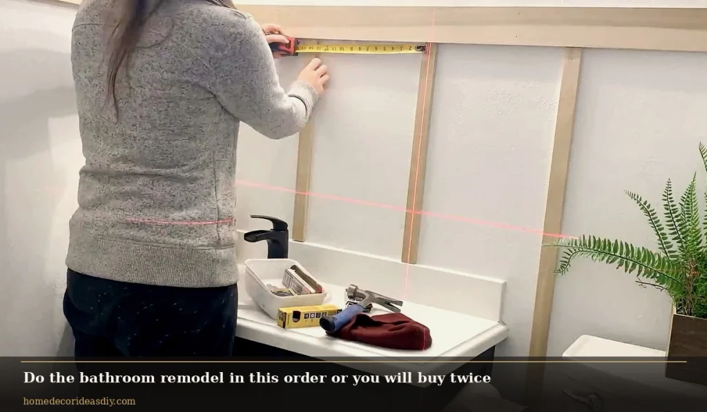 Measuring a bathroom wall before vanity install during a bathroom remodel