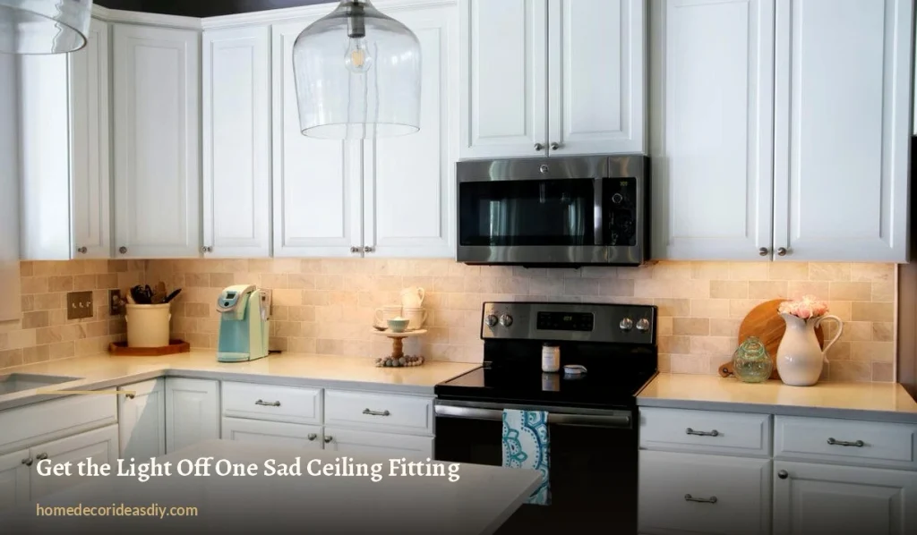 Glass bell pendant light and warm under-cabinet lighting in a white kitchen with stone backsplash