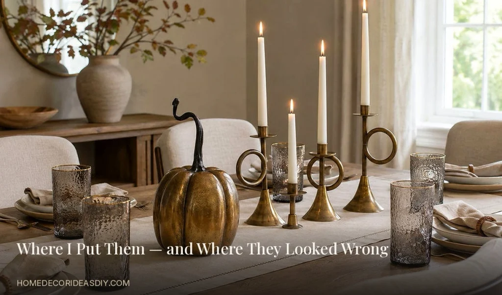 Elegant candle holders styled as a dining table centerpiece with brass tapers and a linen runner.